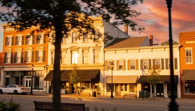 Historic main street brick storefronts bathing in golden hour sunset glow