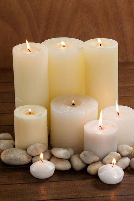 Lit White Candles and Pebbles on Wooden Surface in Spa Center - Download Free Stock Photos Pikwizard.com