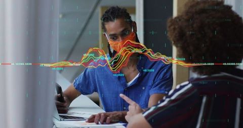 Diverse business team analyzing data with masked discussion in office