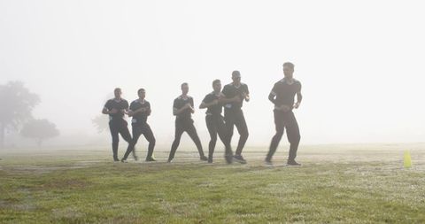 Team running drills in foggy park enhancing endurance and teamwork