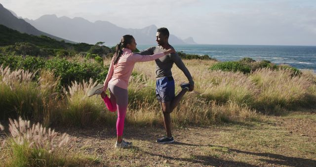 Young man and woman stretching together by scenic ocean view - Download Free Stock Images Pikwizard.com