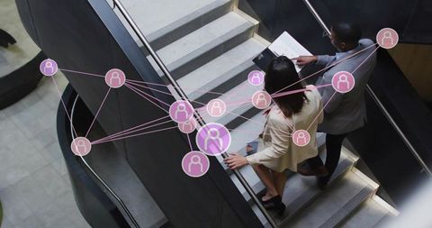 Business team descending office stairs reviewing tablet with digital network overlay