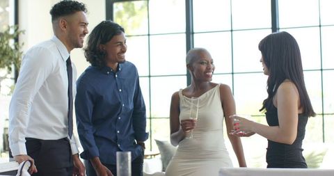 Multicultural friends socializing with african american woman in sunlit modern lounge