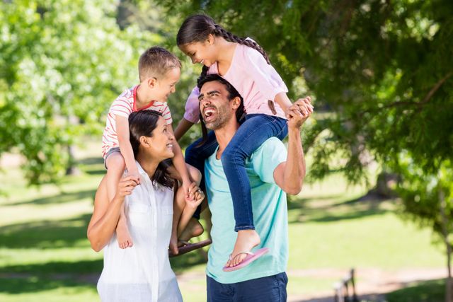 Family enjoying a sunny day at the park, perfect for promoting family activities, outdoor fun, and leisure time. Ideal for advertisements, family-oriented content, and lifestyle blogs.