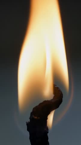 Vertical close-up flickering candle flame over charred wick, ambient warm minimalist video loop