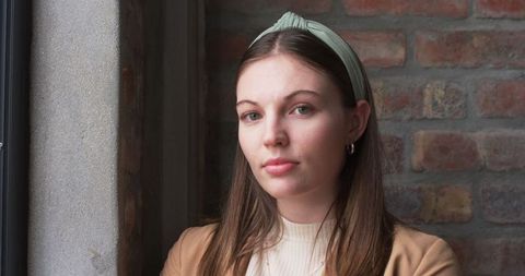 Young Professional Woman Stands near Window with Brick Background - Download Free Stock Images Pikwizard.com