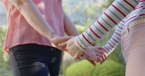 Mother and Daughter Holding Hands in Tranquil Garden