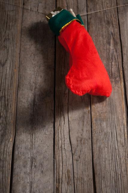 Christmas stocking with present box hanging against wooden wall during christmas time