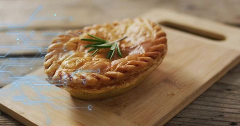Golden rustic meat pie on wooden cutting board with rosemary and futuristic circuit overlay