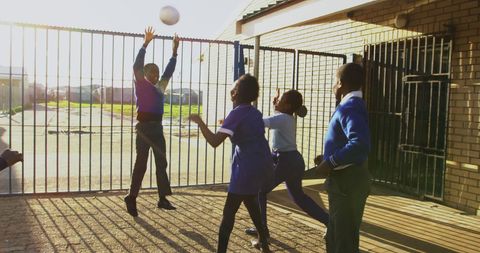 Children Playing Ball Joyfully Outside Urban Schoolyard