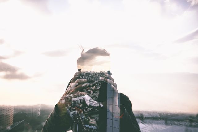 This abstract image showing a man capturing a cityscape with a camera and double exposure effect combining his silhouette with the skyline creates a dreamy, artistic look. Ideal for use in creative projects, photography websites, modern design, urban lifestyle blogs, architectural presentations, and marketing materials promoting city life or photography services.