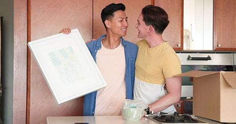 Diverse Male Couple Unpacking New Home Together