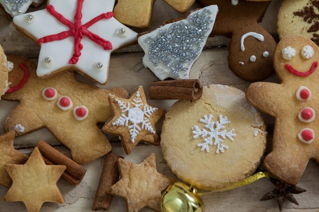 Assorted Christmas cookies including gingerbread men, snowflake cookies, and star-shaped cookies arranged on a wooden plank. Ideal for holiday-themed promotions, festive recipe blogs, Christmas cards, and seasonal advertisements.