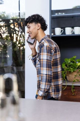 Young Man Conversing on Smartphone in Stylish Kitchen