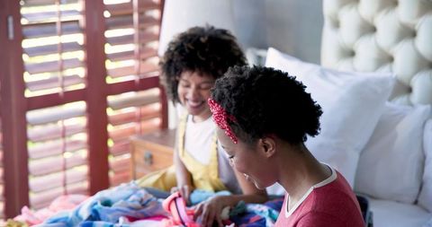 Lesbian Couple Joyfully Packing for Vacation Together at Home