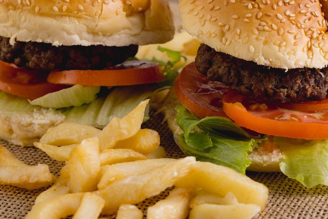 Close-up of burgers with french fries on burlap, copy space. unaltered, food, fried food and unhealthy eating.