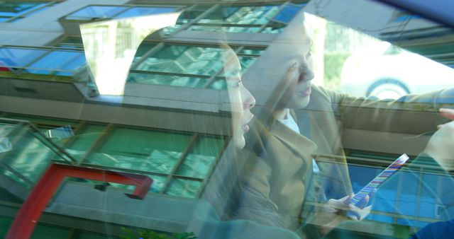 Two Women Conversing in Car with Reflections on Windows - Download Free Stock Images Pikwizard.com