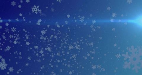 Falling snowflakes on deep blue gradient with soft lens flare and bokeh