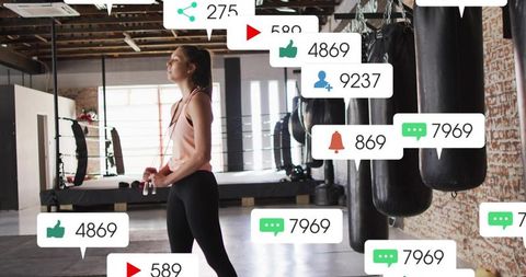 Female athlete holding jump rope and training in boxing gym with social media overlays