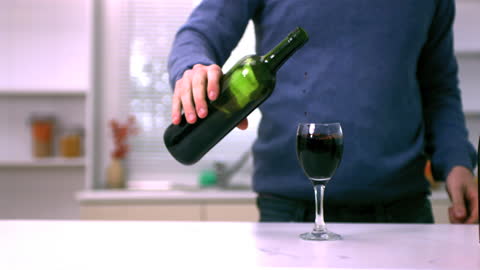 Man Pouring Red Wine into Glass in Slow Motion Scene