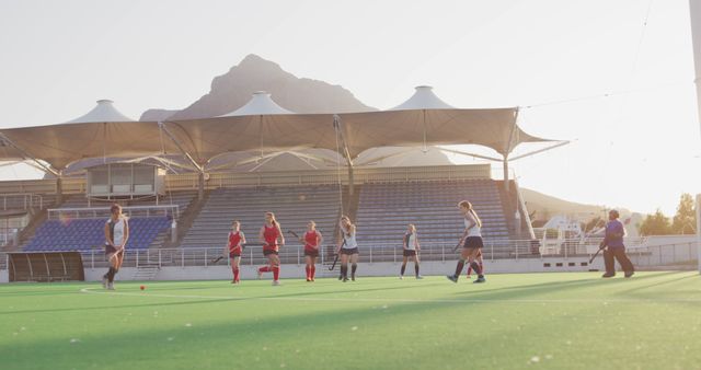 Female Athletes Playing Field Hockey in Stadium at Sunset - Download Free Stock Images Pikwizard.com