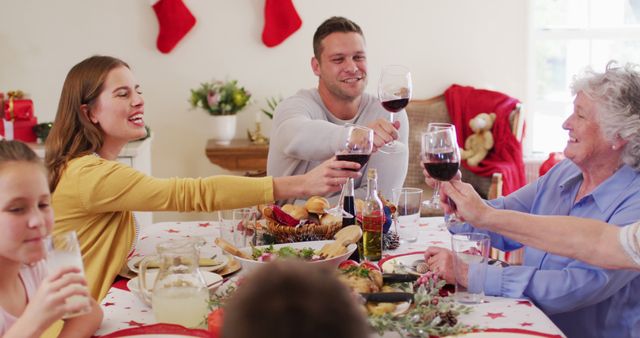 Family Celebrating Christmas with Toast at Dinner Table - Download Free Stock Images Pikwizard.com