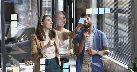 Diverse team brainstorming with glass sticky notes in modern office