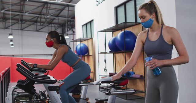 Women Exercising on Stationary Bikes While Following Covid-19 Safety Protocols - Download Free Stock Images Pikwizard.com