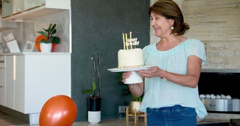 Smiling Woman Holding Cake at Home Celebration