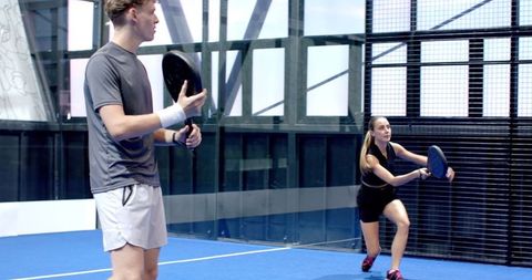 Focused Teamwork on Blue Turf Padel Court: Intense Rally