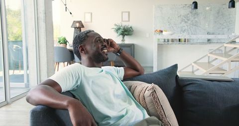 African American Man Relaxing on Sofa in Modern Living Room