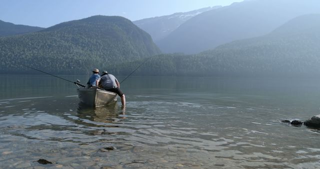 Men fishing in a boat in serene mountain lake - Download Free Stock Images Pikwizard.com