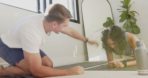 Diverse Workout Partners Planking Together at Home