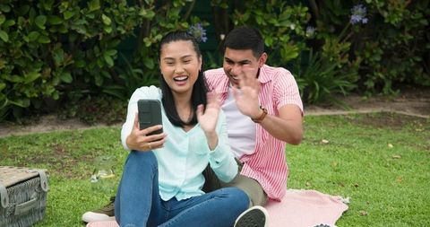 Happy Asian Couple Chatting Outdoors on Sunny Day
