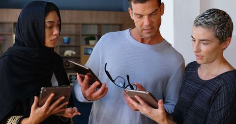 Diverse team collaborating using tablets in modern office