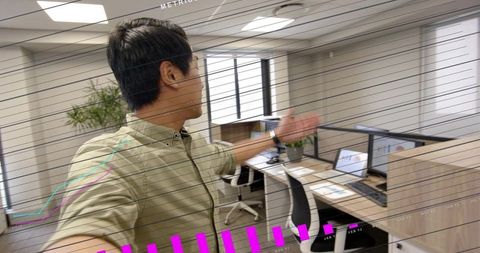 Worker gesturing through augmented reality HUD in modern open-plan office with data graphs