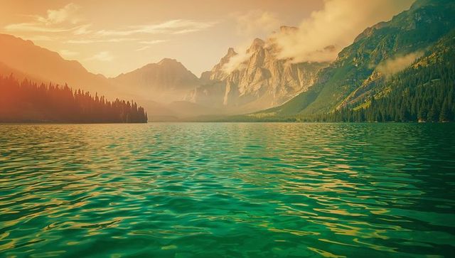Tranquil emerald lake with mountains and pine forest