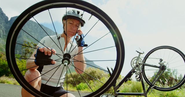 Cyclist Repairing Bicycle Wheel Outdoors on Scenic Route - Download Free Stock Images Pikwizard.com