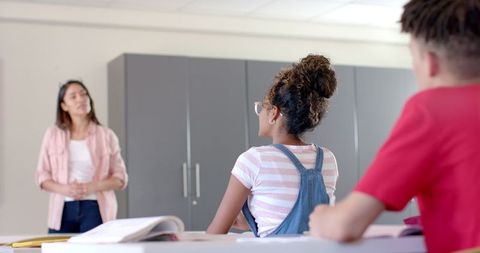 Engaged high school classroom with confident young teacher