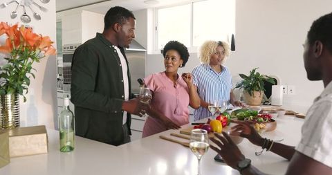 Group of Friends Socializing in Modern Kitchen with Drinks