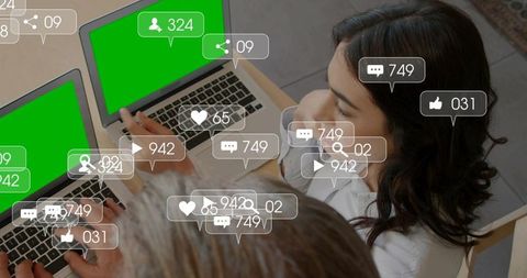 Overhead collaboration on laptops with social media engagement icons and green screens