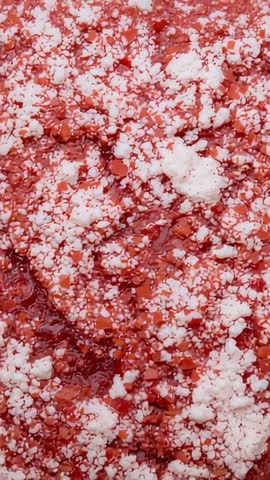 Vertical Macro Video Showing Glossy Crimson Paste with Shifting White Clumps