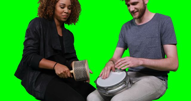 Happy musicians playing cabasa and drum against green screen