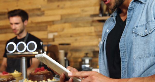 Customer Using Tablet in Modern Coffee Shop with Barista in Background - Download Free Stock Images Pikwizard.com