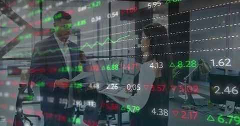 Colleagues reviewing financial reports with market data overlay in modern open office
