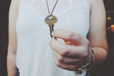 Person holding key necklace with inspirational message
