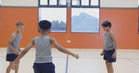 Boys Practicing Basketball in School Gym for Team Building