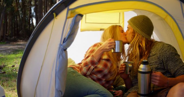 Young couple kissing while having coffee in tent. Couple drinking coffee 4k