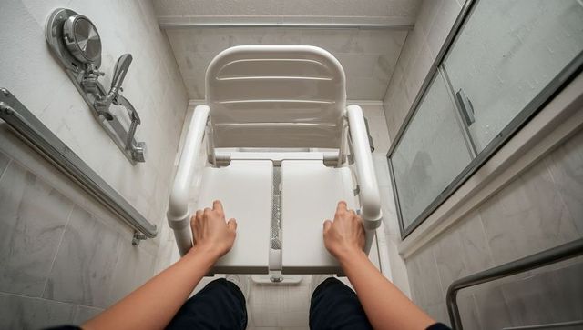 Person using shower chair in accessible bathroom for safety