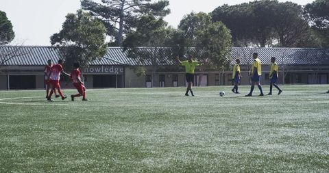 Youth soccer players team building on sunny sports field